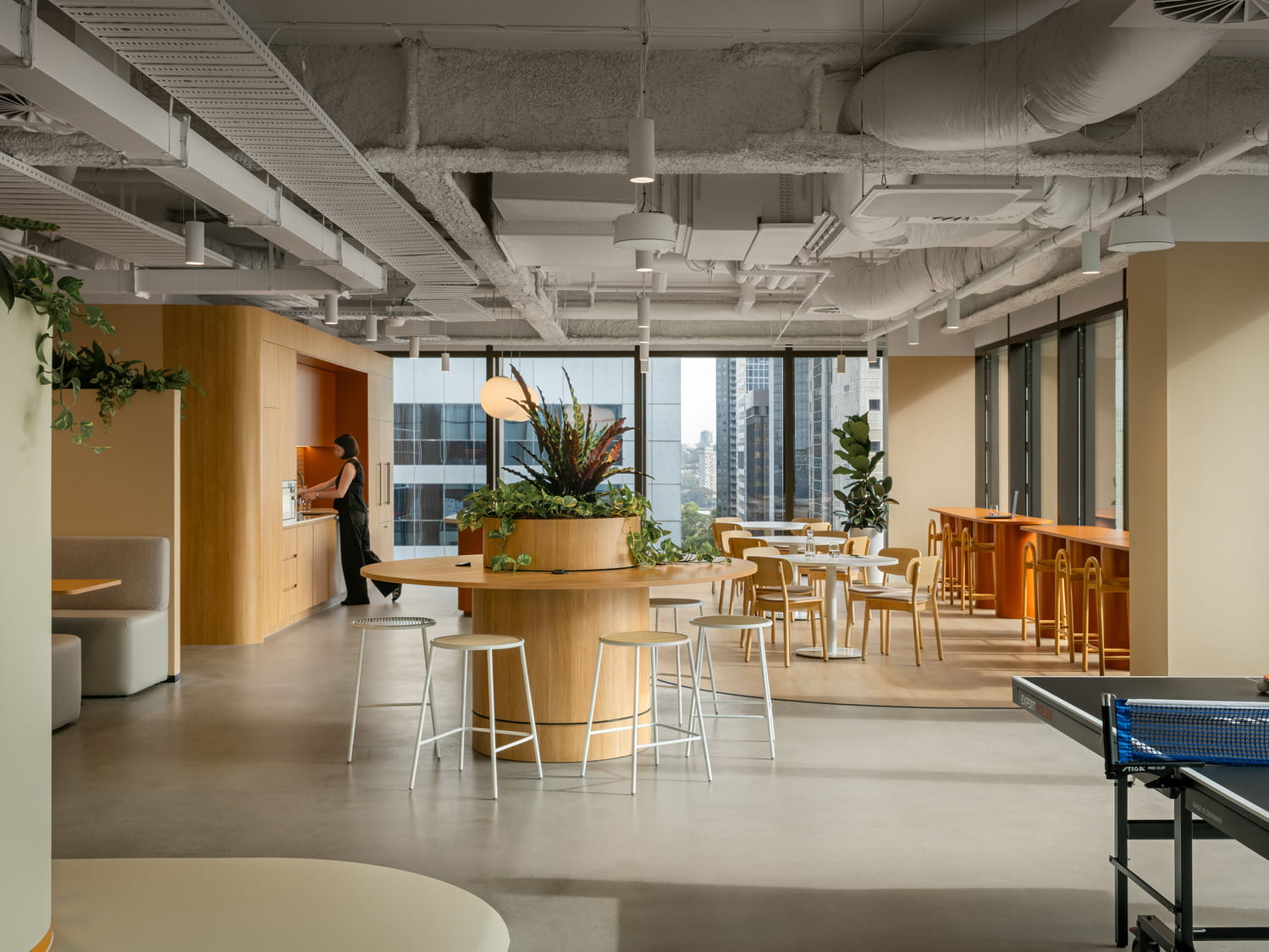 Modern office lounge space with communal seating and city views